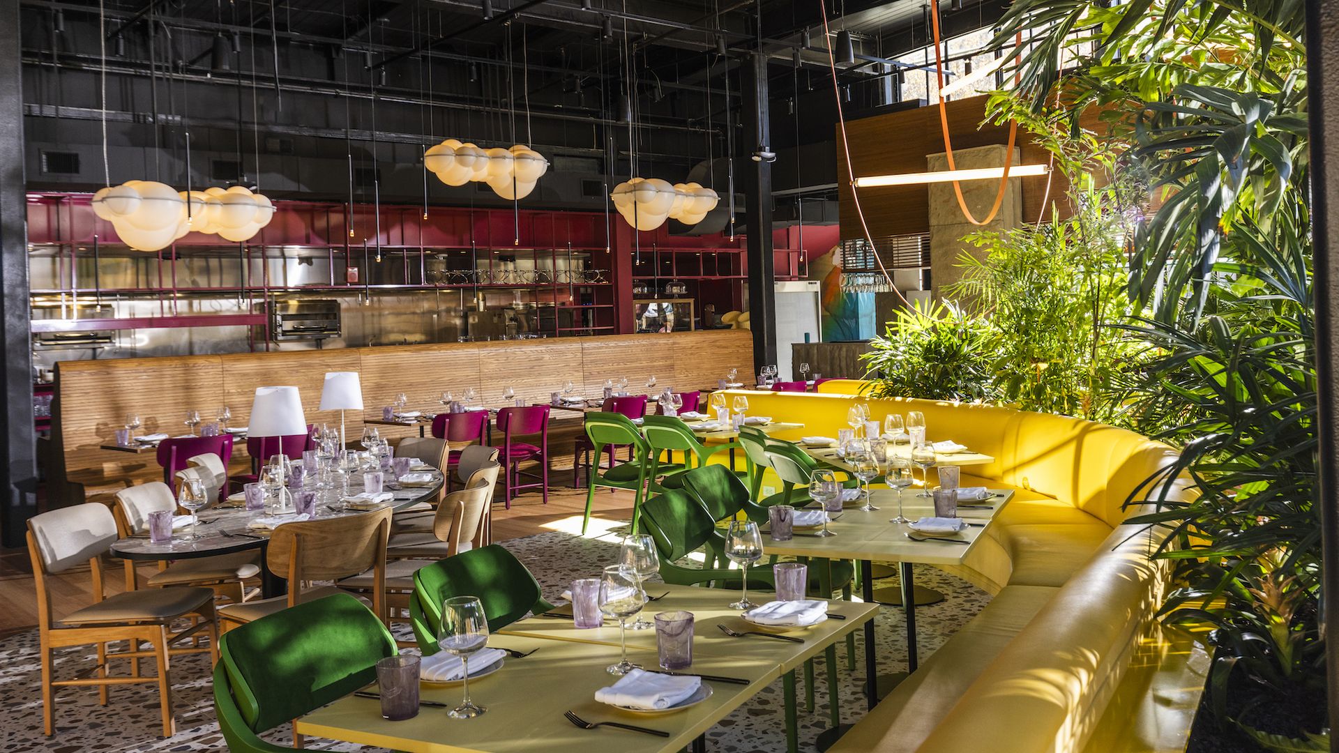 Surreal dining room with yellow banquettes and plants