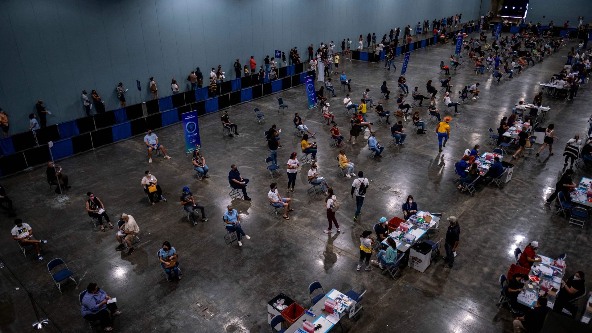 People attend the first mass vaccination event to get inoculated with the Johnson and Johnson Covid-19 vaccine at the Puerto Rico Convention Center in San Juan, Puerto Rico on March 31, 2021.