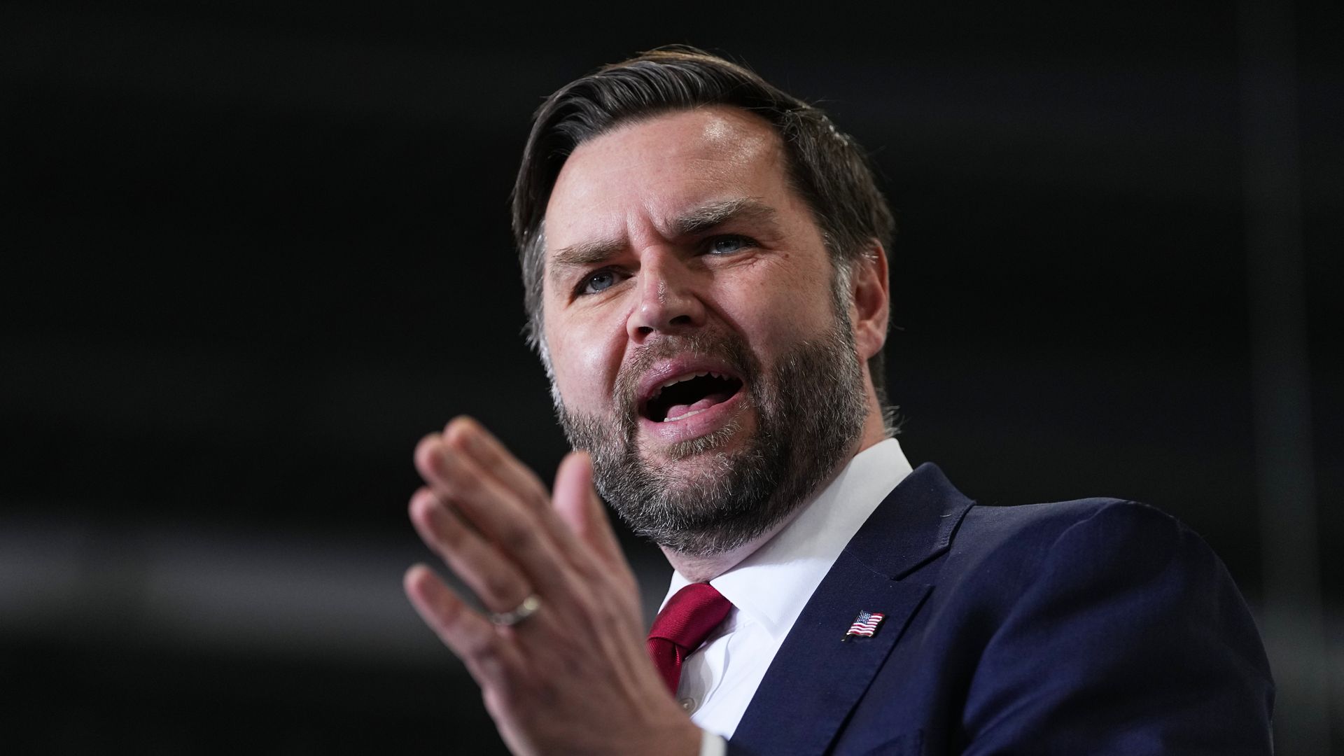 Vice President Vance speaks, raising his left hand.