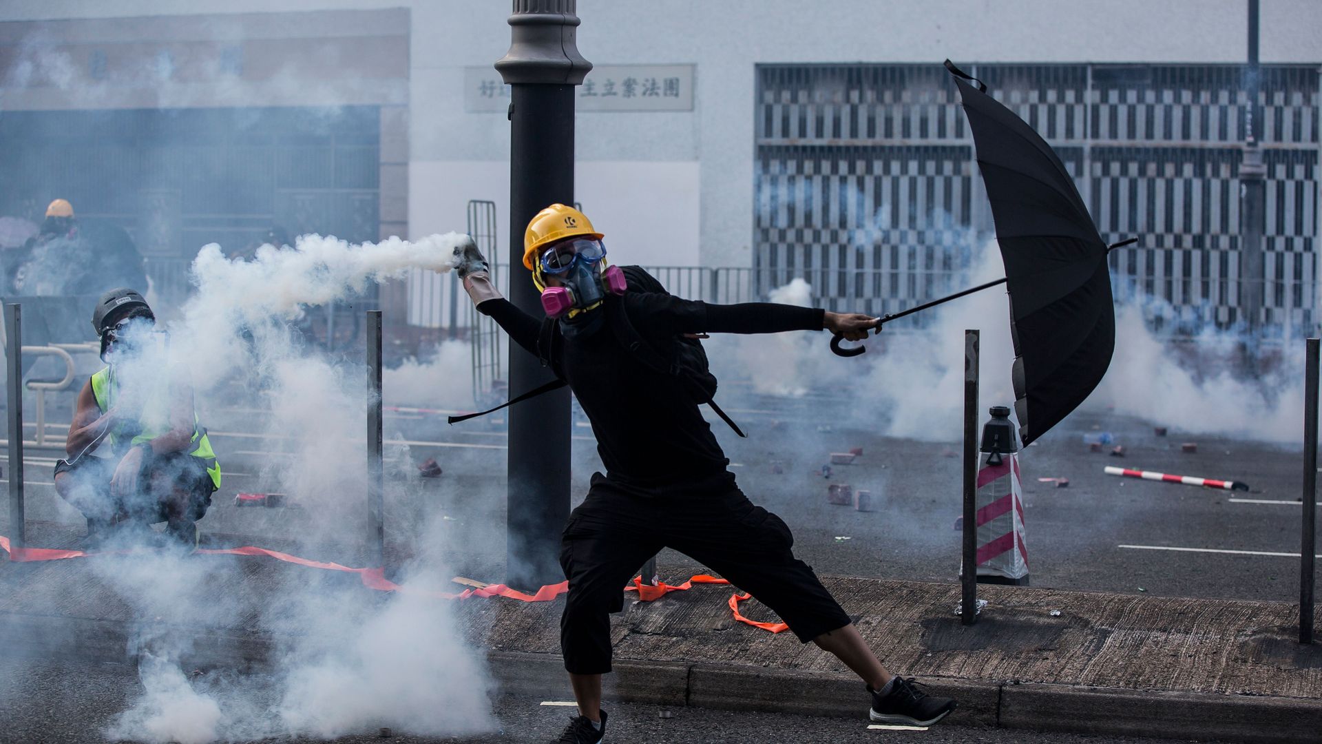 Photo of a Hong Kong protester with umbrella and tear gas