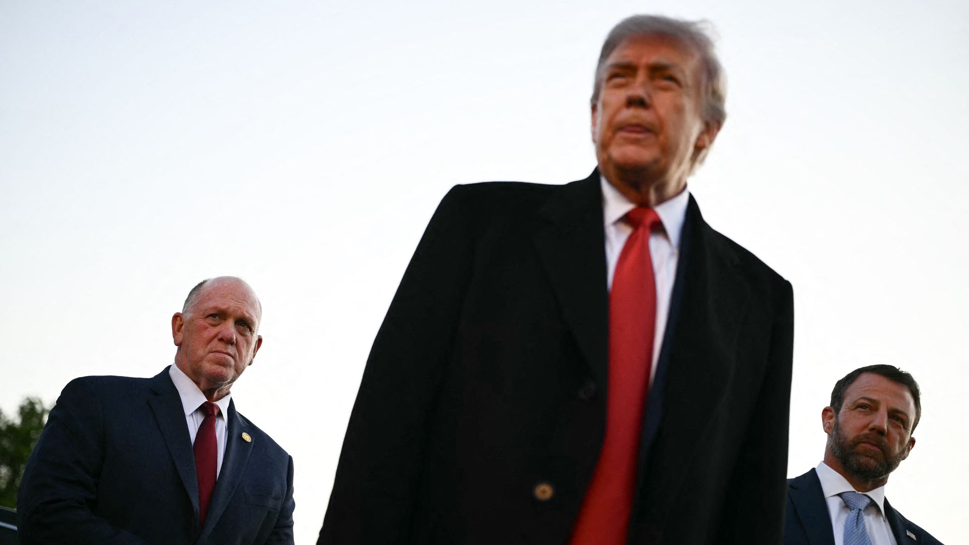 US President Donald Trump, flanked by White House 'border czar' Tom Homan (L) and US Secretary of Homeland Security Markwayne Mullin (R), speaks with workers who have been painting the Lincoln Memorial Reflecting Pool in Washington, DC, on May 7, 2026.