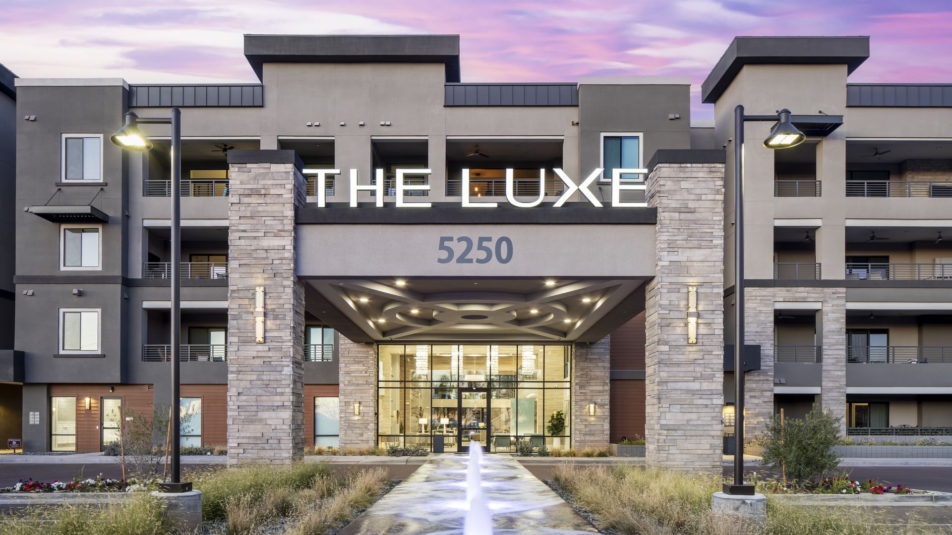 A condo complex with a sign that says, "The Luxe."