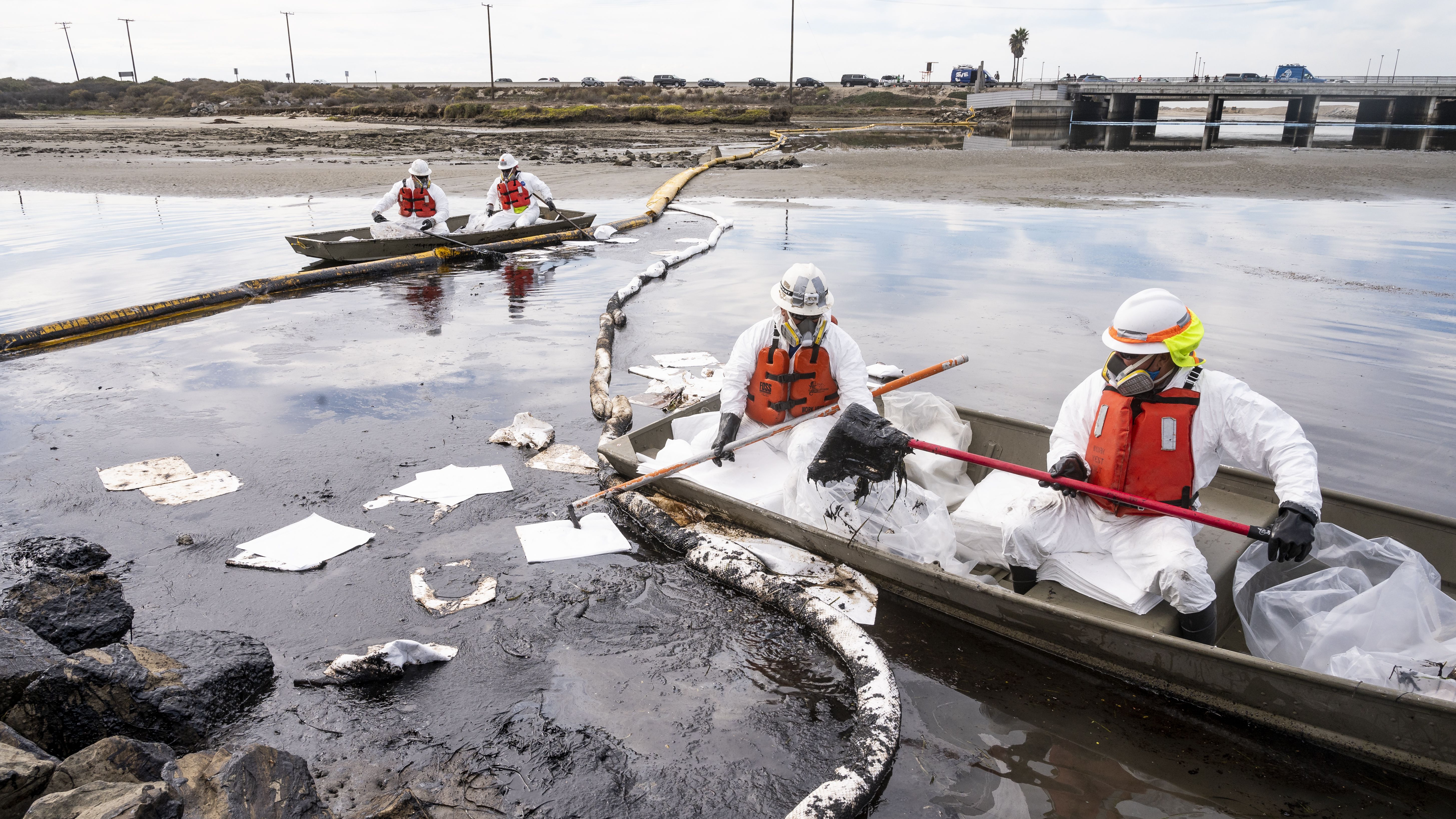 Workers with Patriot Environmental Services mop up oil on the surface of the water at Talbert Marsh in Huntington Beach, CA on Monday, October 4, 2021. 