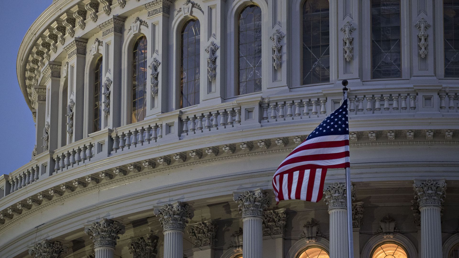 The American flag flies outside the U.S. Capitol before sunrise in Washington, D.C.