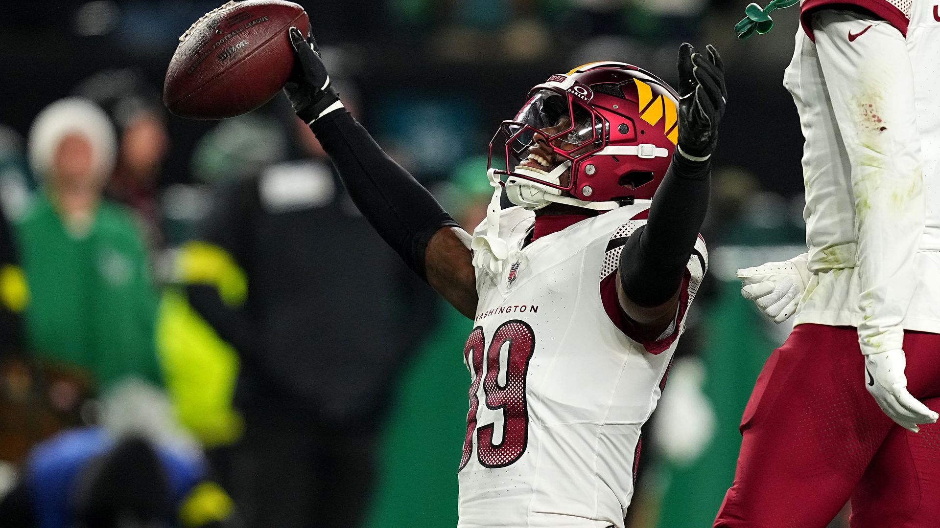 Commanders player celebrates while gripping football
