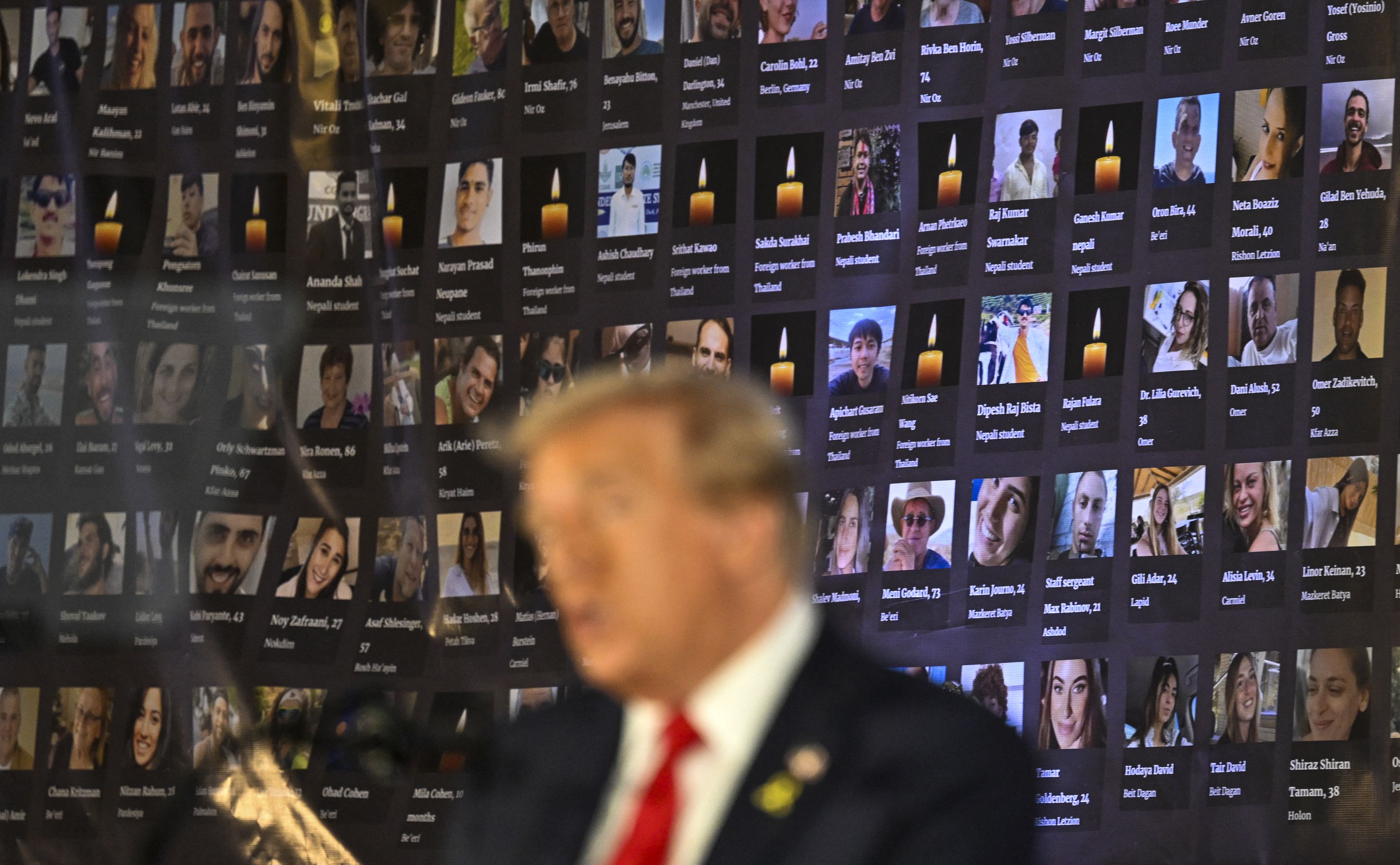 Trump stands in front of photos of hostages