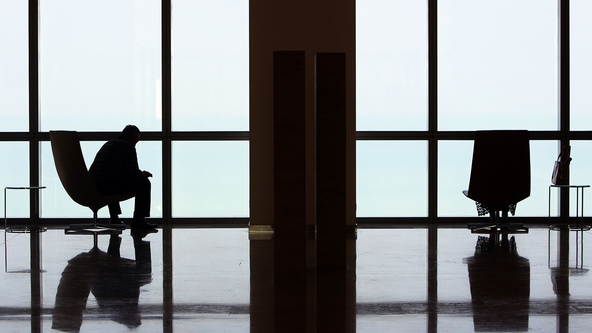A man sitting alone in a chair looking out the window
