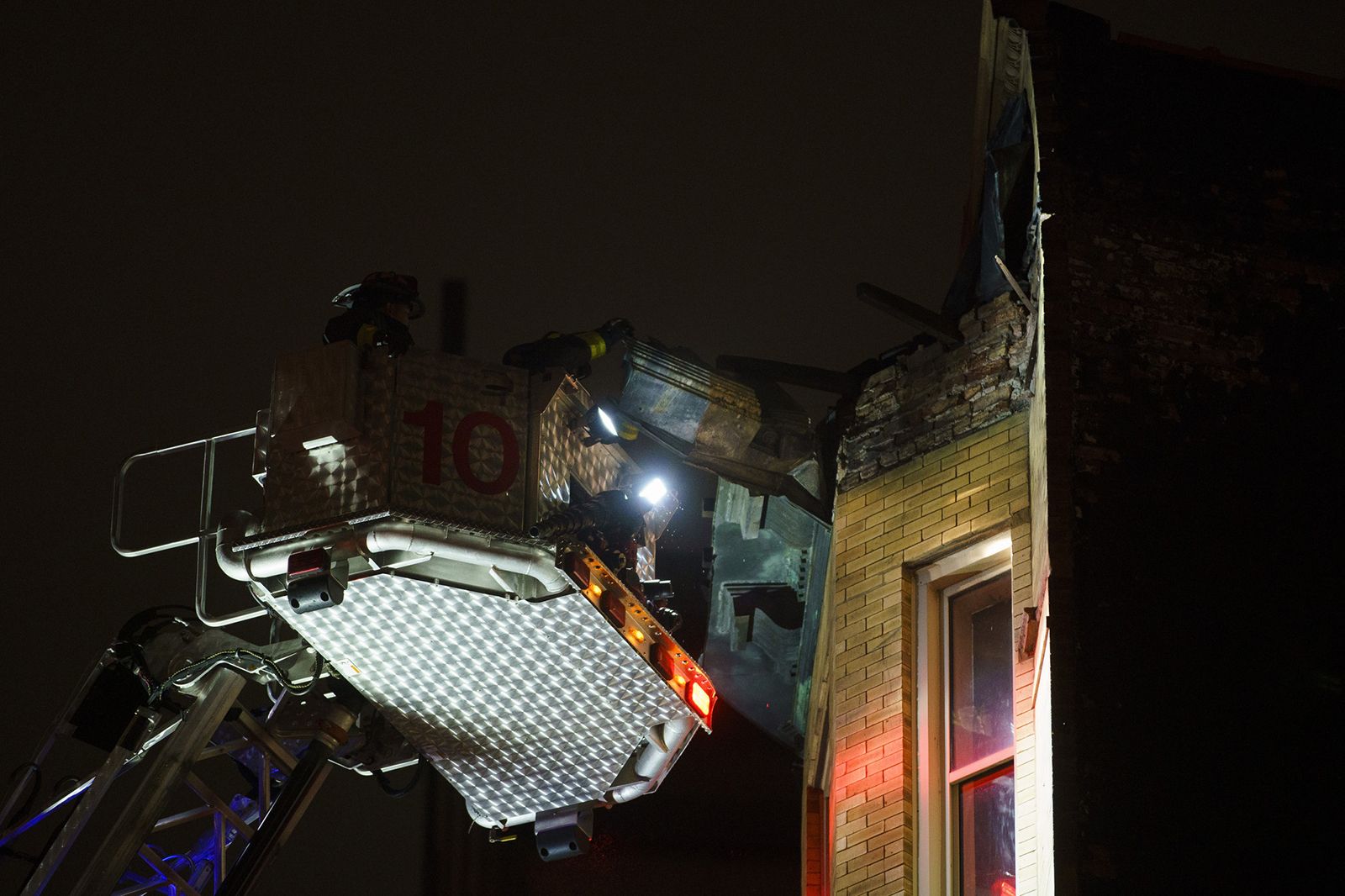 Photo of firefighters removing a section from a collapsed house