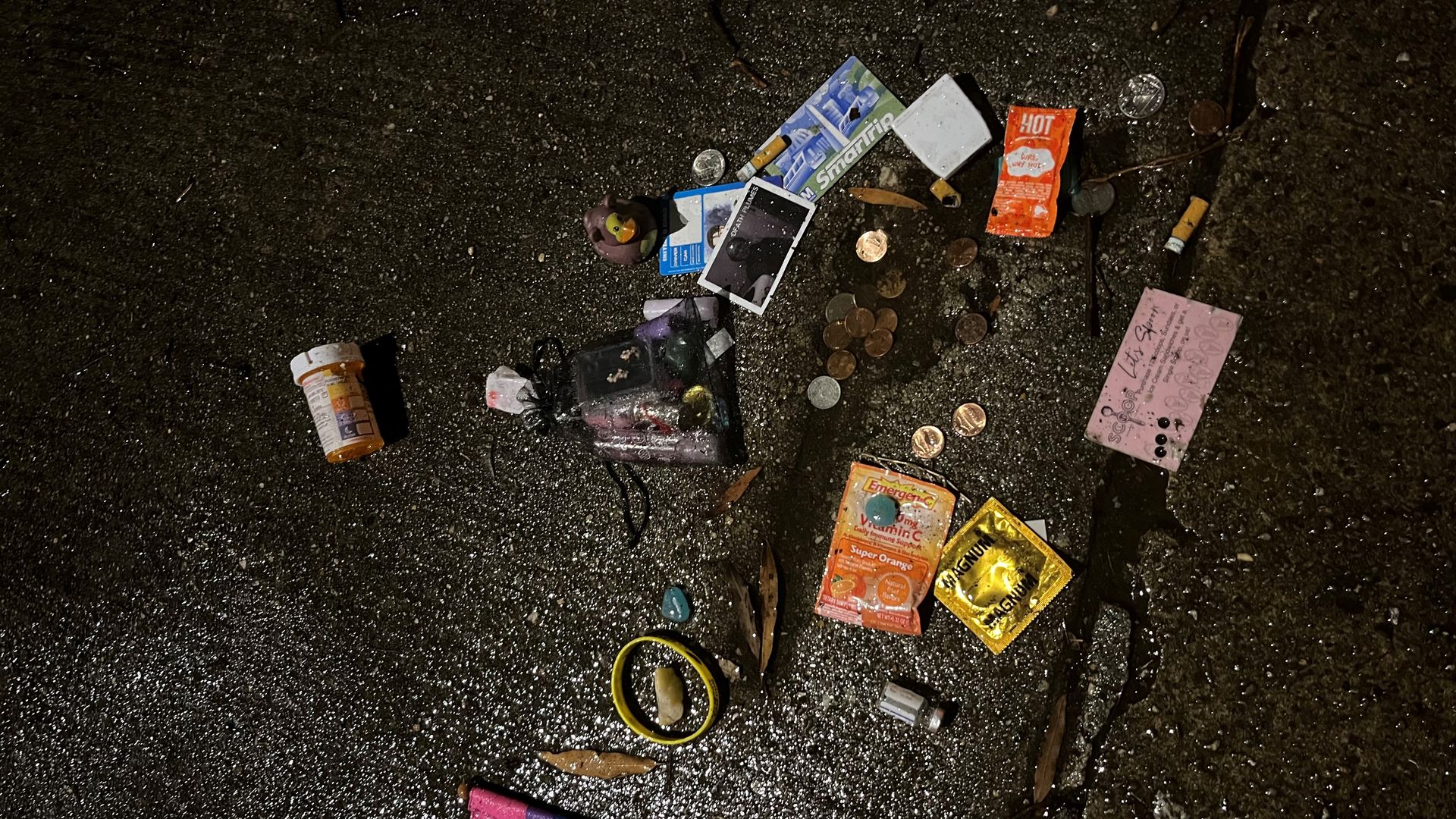 a gun-shaped sidewalk hole filled with trash 
