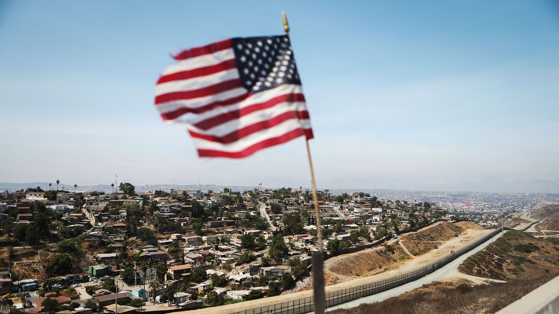 American flag flying above border with Mexico