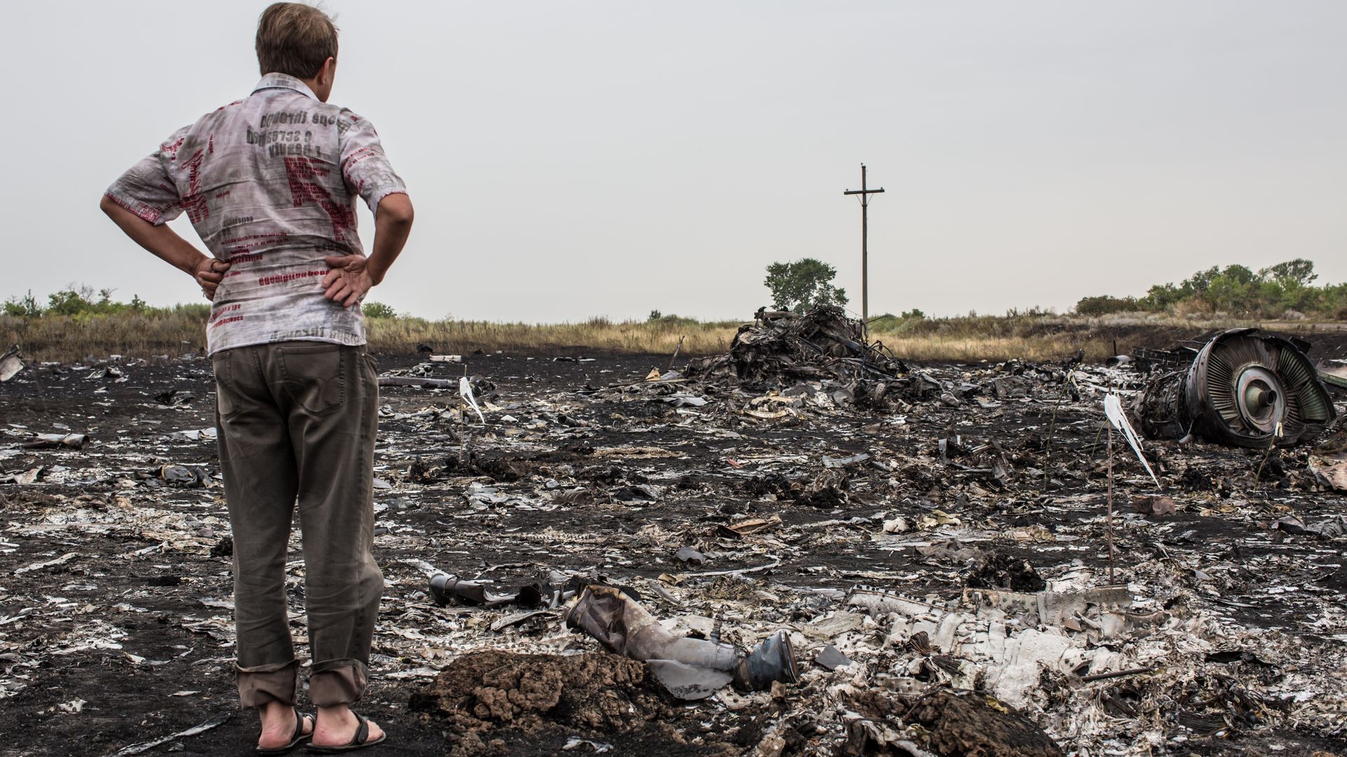 A man looks at debris from an Malaysia Airlines plane crash on July 18, 2014 in Grabovka, Ukraine. Photo: Brendan Hoffman/Getty Images