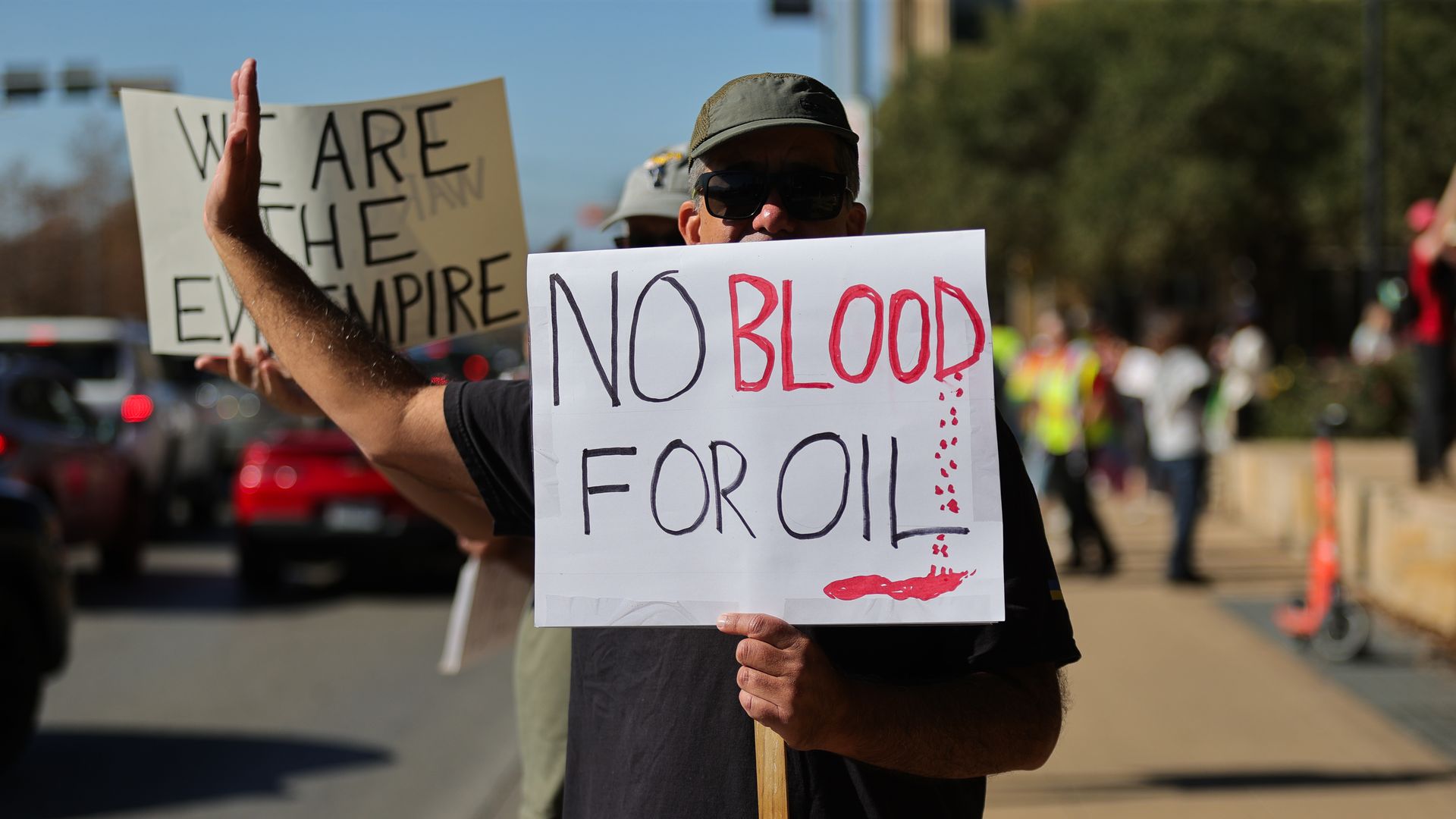 Protester holds sign that reads "no blood for oil." 