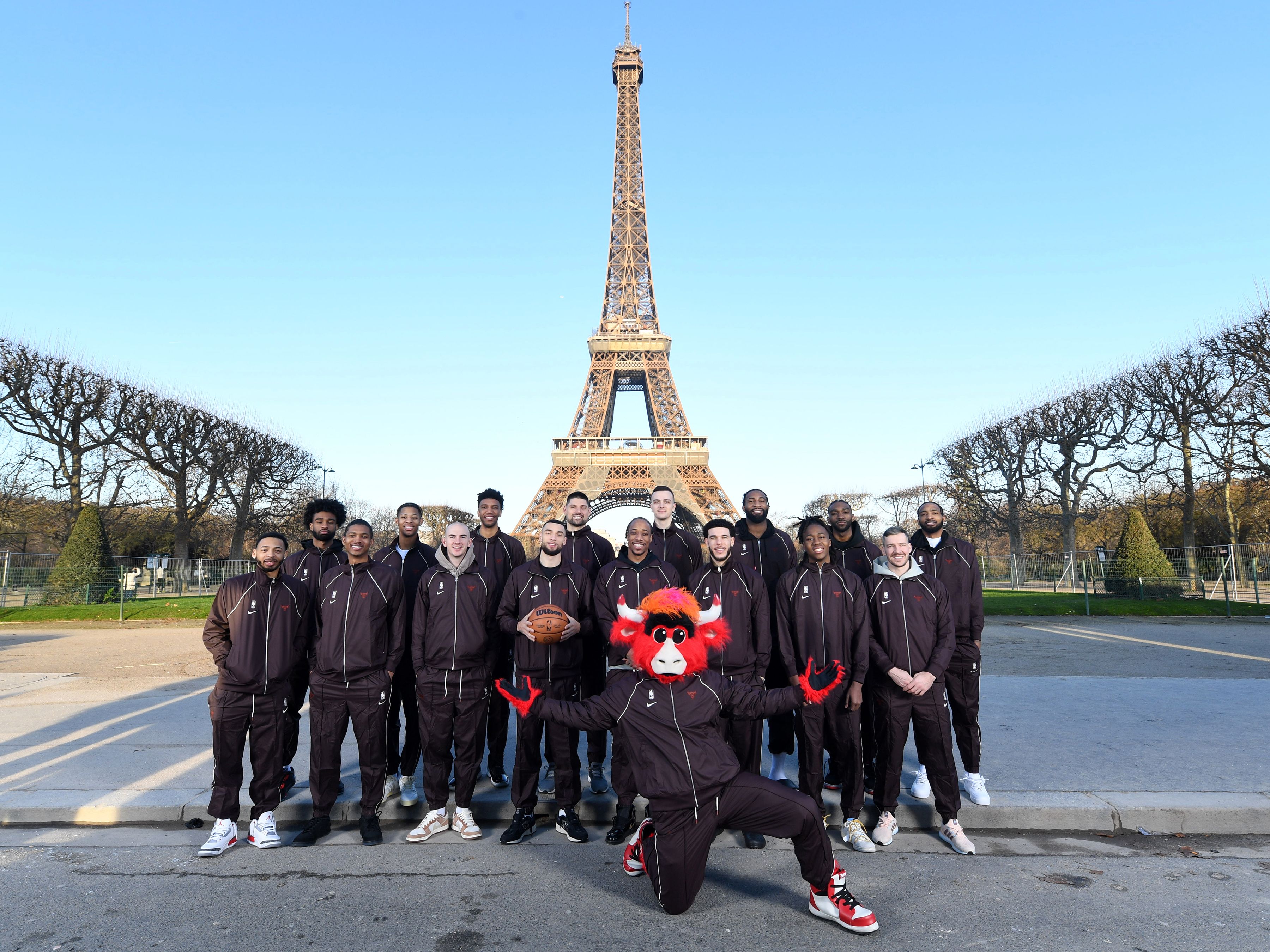 Photo of a team posing in front of the Eiffel Tower