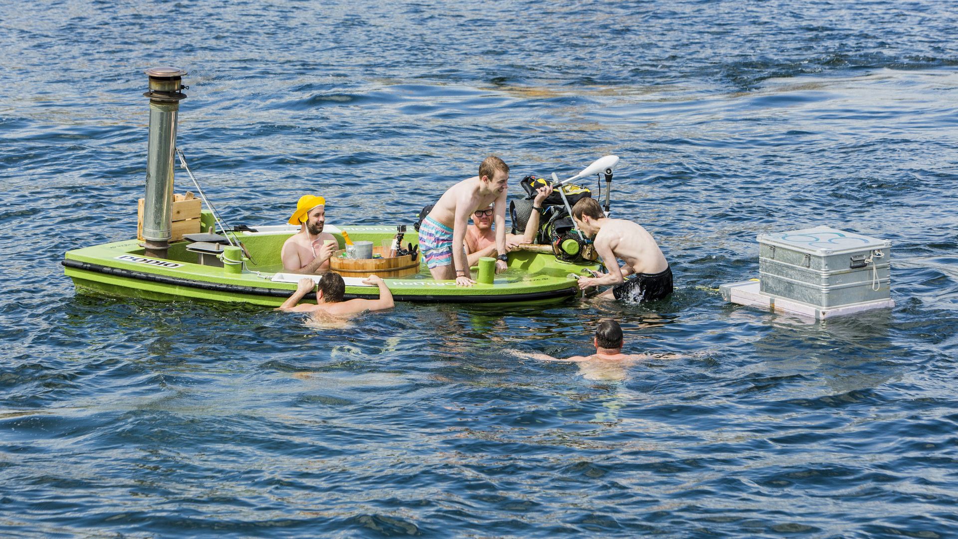 Young men sit in a floating bathtub with heated water inside on May 3, 2014 in the harbour of Copenhagen, Denmark.
