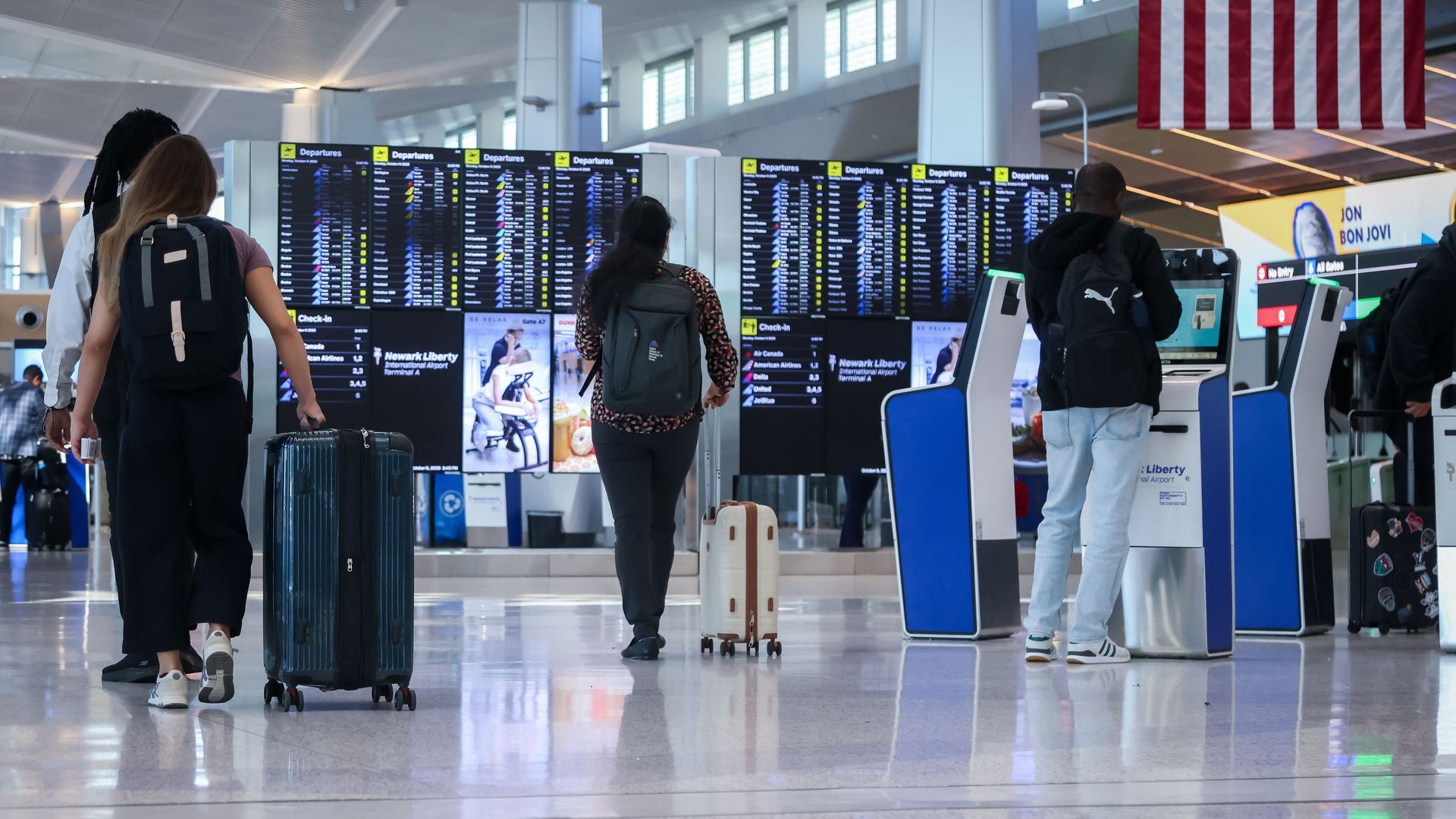 Travelers push suitcases through an airport.