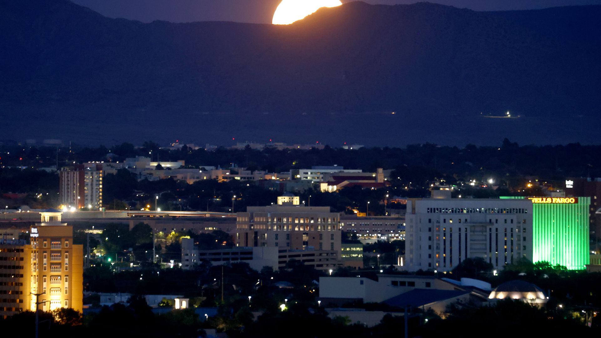 The Sturgeon Moon rises beyond the city on August 11, 2022 in Albuquerque, New Mexico.