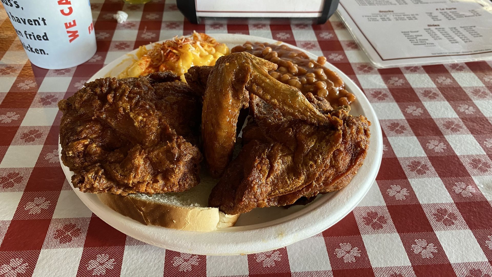 A plate of fried chicken, baked beans and macaroni and cheese. 