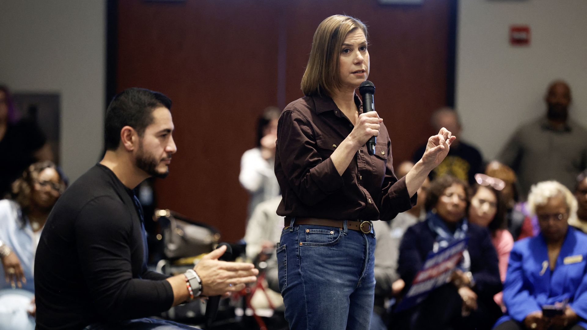 Democrat US Senate candidate Abdul El-Sayed (L) reacts as US Senator Elissa Slotkin (D-MI) speaks during a town hall campaign event
