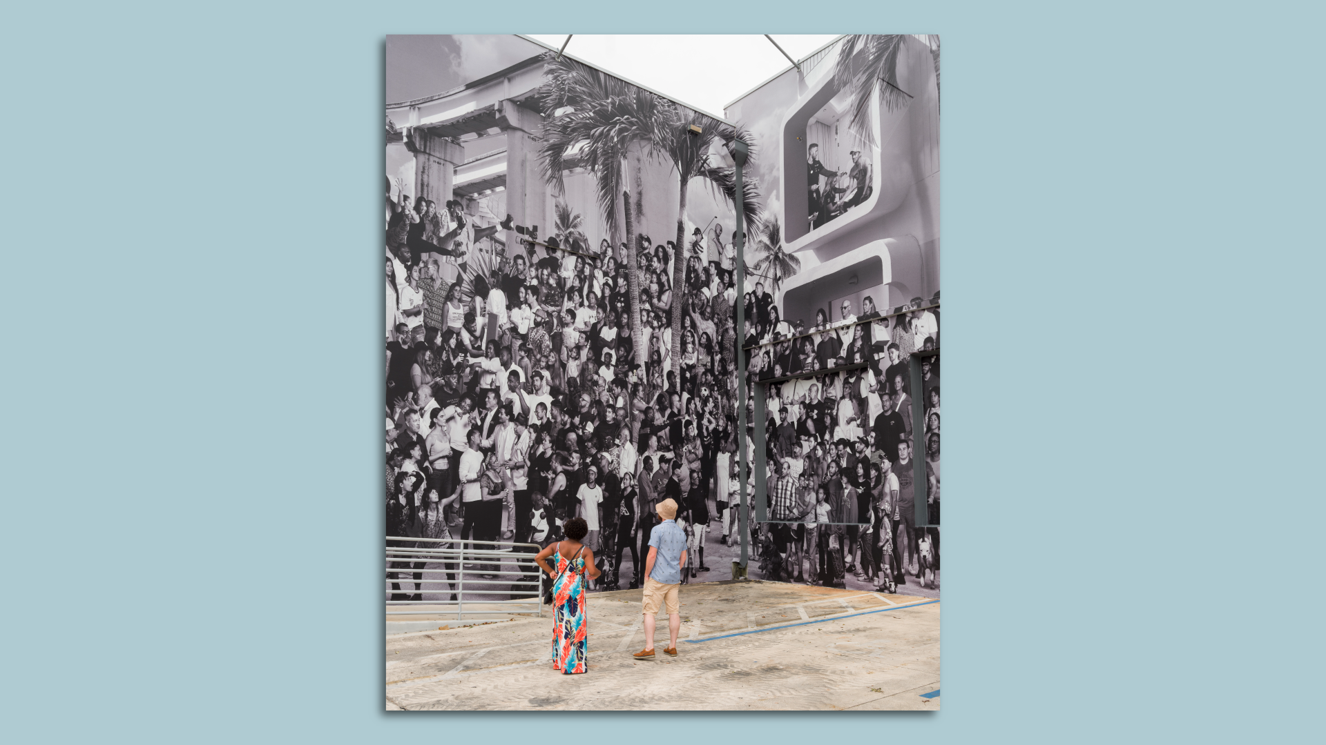 Two people look at a mural made up of over 1,000 Miami locals and celebrities.