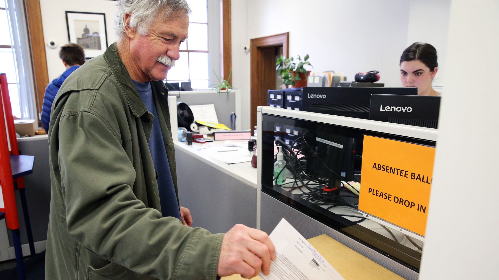 A man casts an absentee ballot 