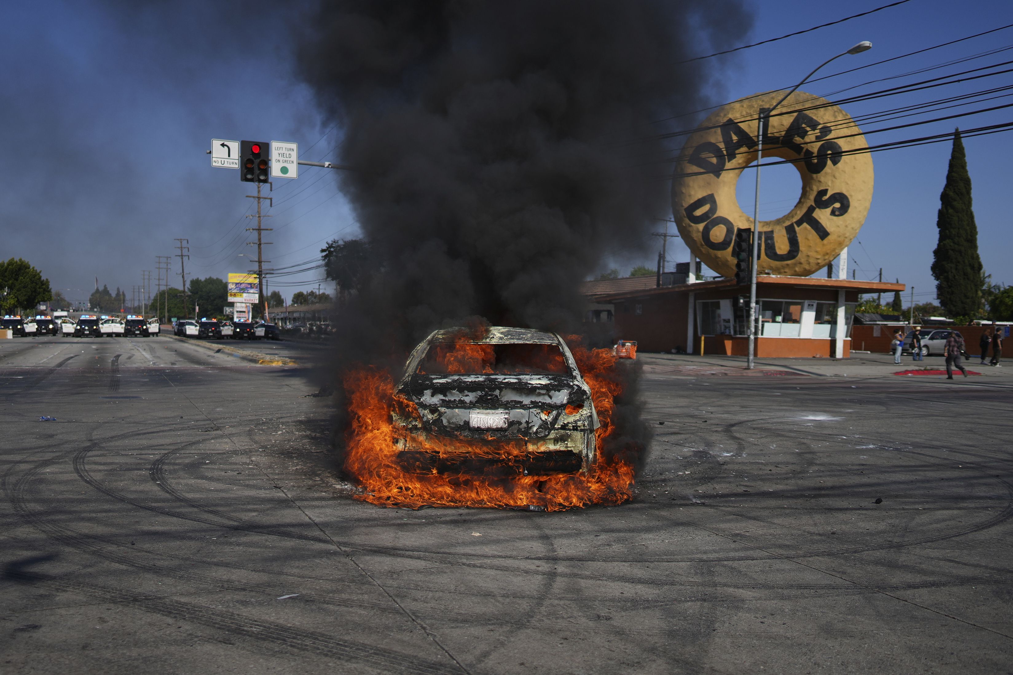 A car burns during a protest in Compton, Calif., Saturday, June 7, 2025, after federal immigration authorities conducted operations. (AP Photo/Eric Thayer)
