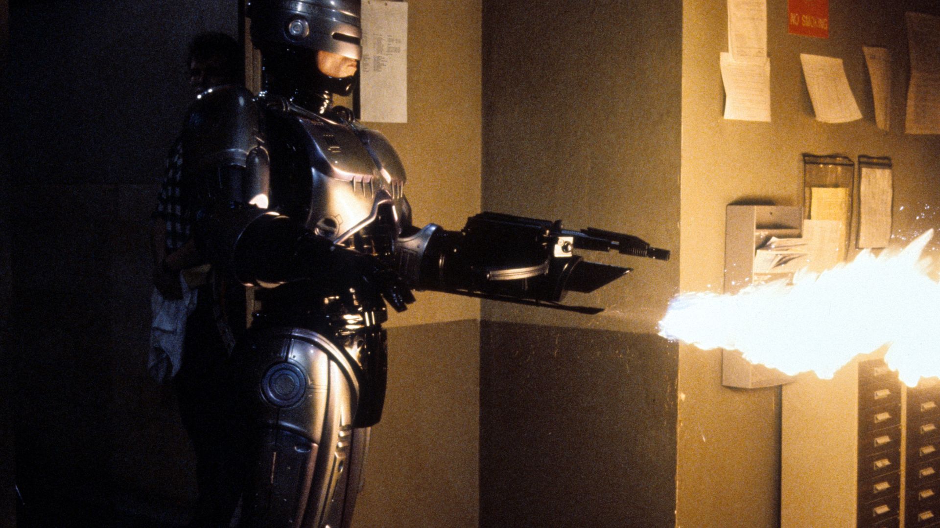 A photo of Robocop using a flamethrower in a dark room