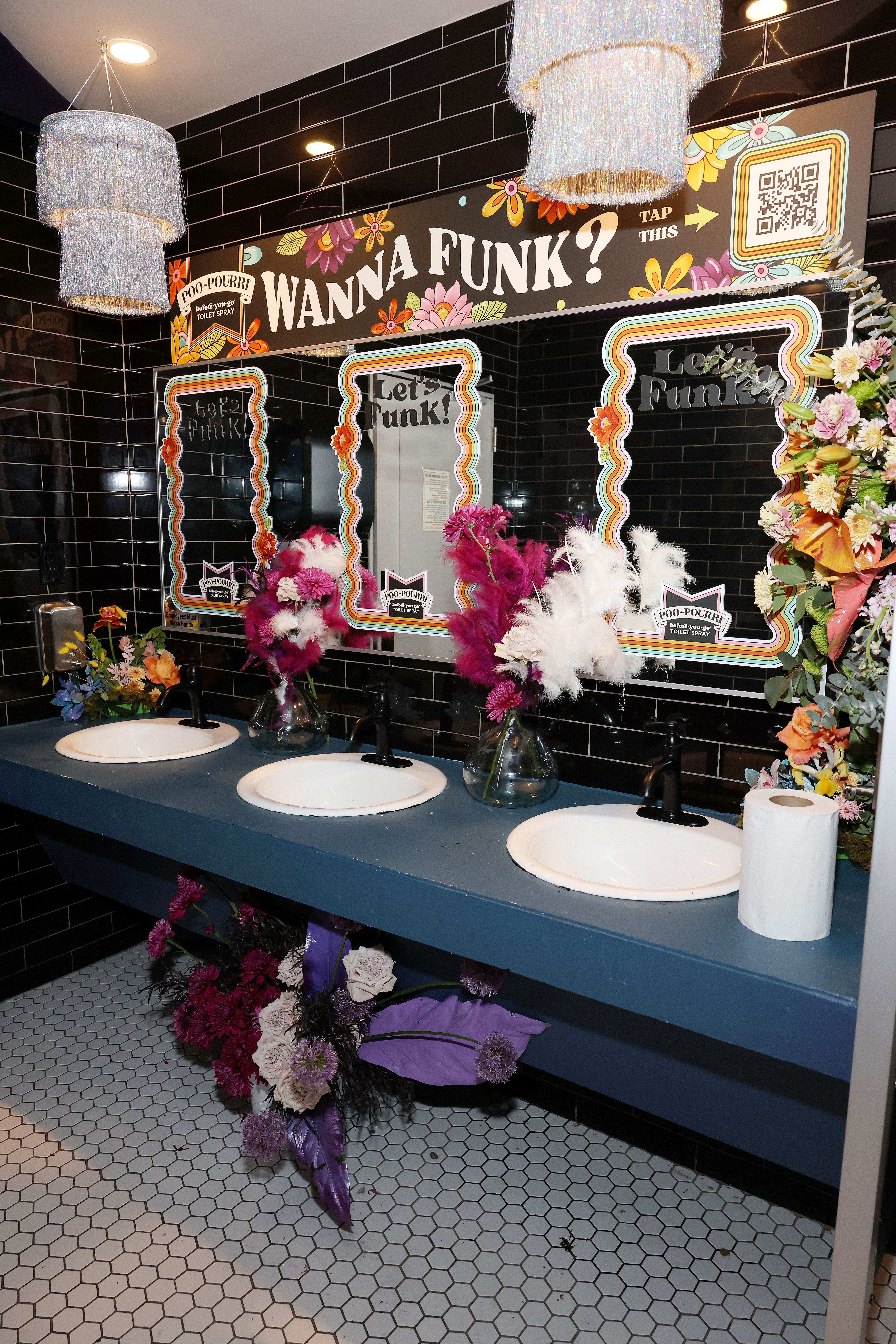 Three bathroom sinks with flowers on the counters