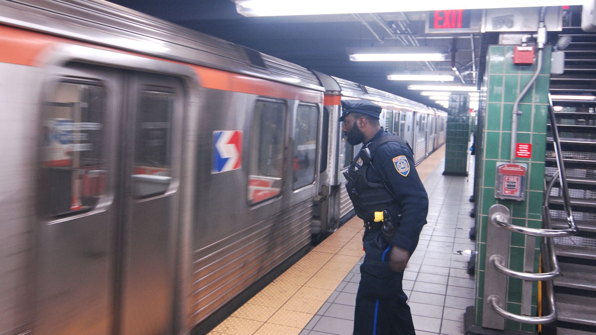 A transit police officer waits at the Broad Street Line to stop at Erie station.