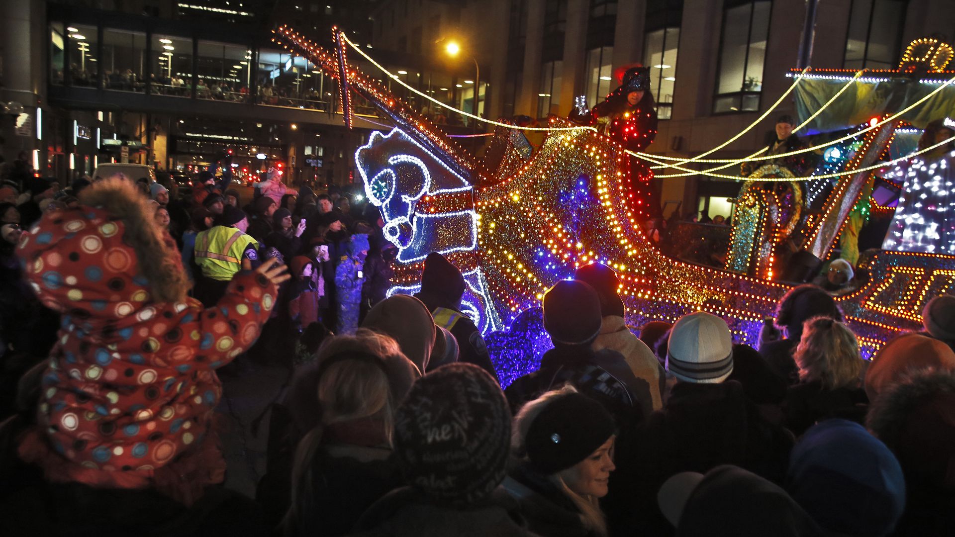 People line the streets for a parade float during Holidazzle in 2009