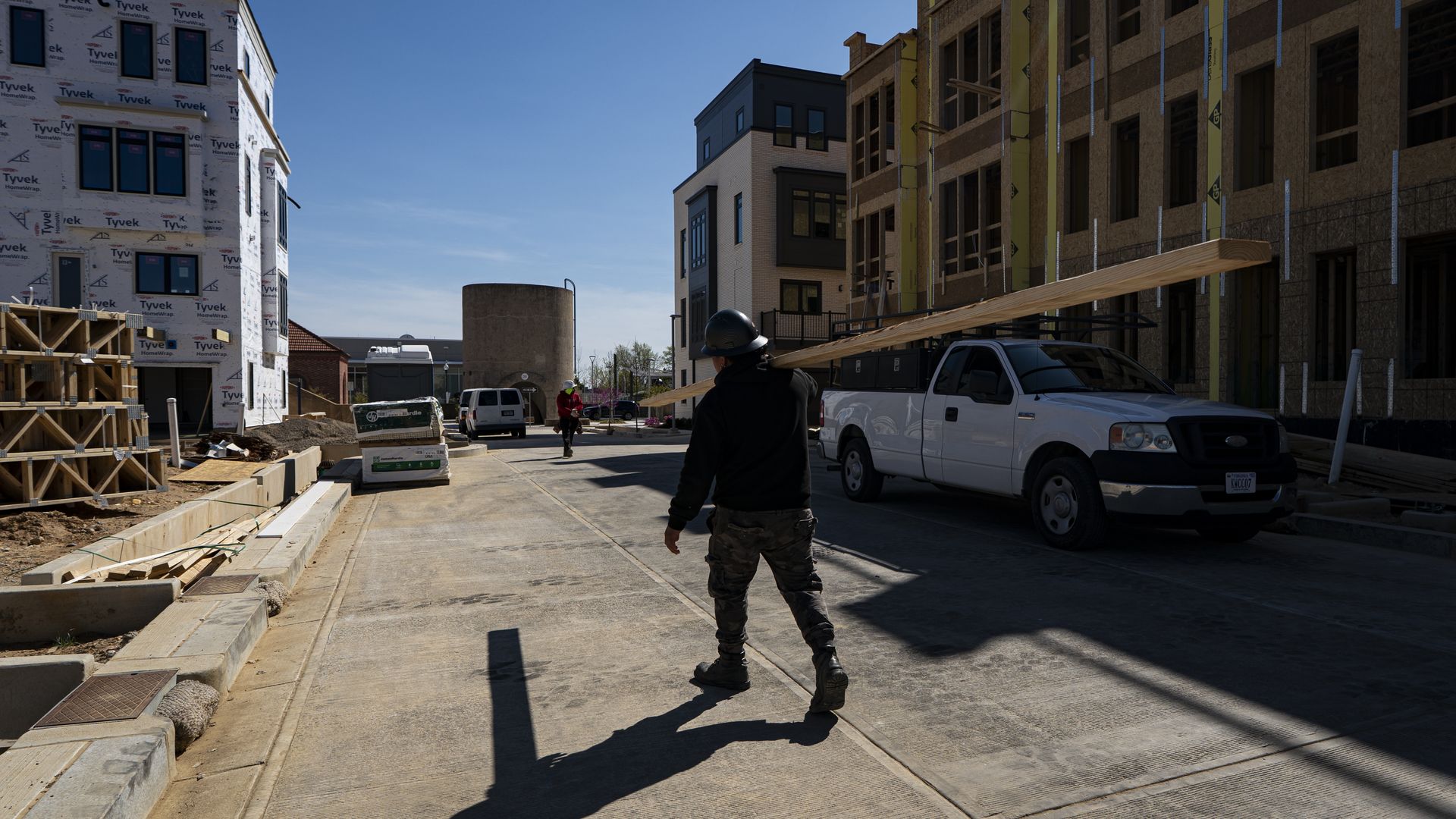 A construction worker carries materials on a housing site