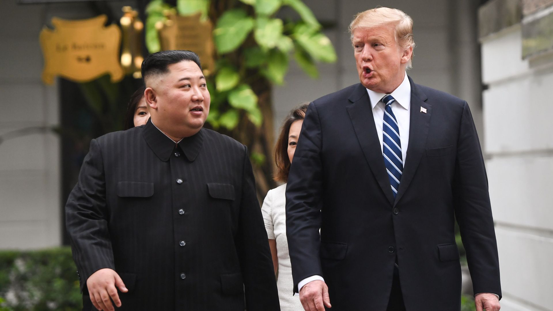 In this image, President Trump and Chairman Kim walk outside next to each other.