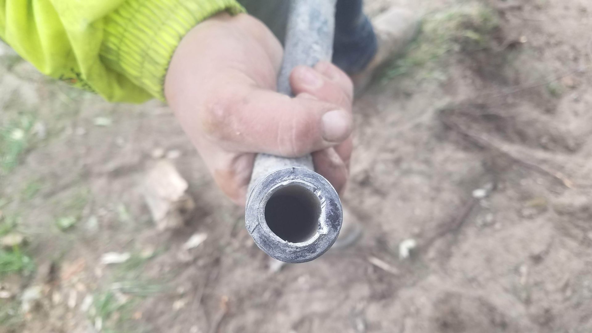 a hand holds a lead pipe. 