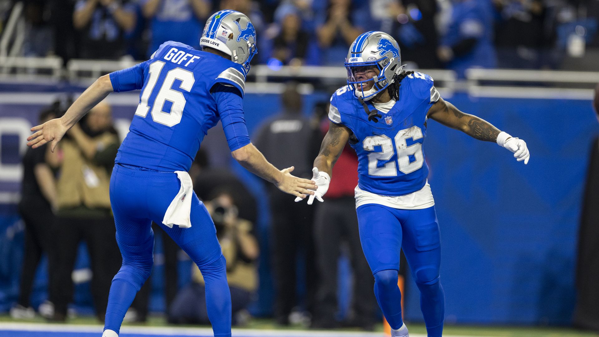 Jahmyr Gibbs celebrates with Jared Goff against the Washington Commanders in January. 