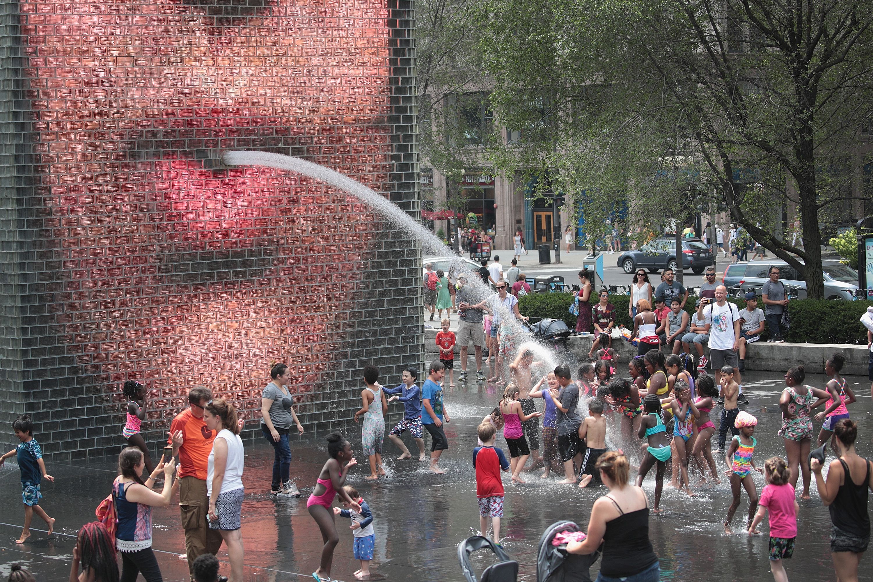 People cool off downtown in Crown Fountain as temperatures climb into the 90's with a heat index expected to reach as high as 115 degrees on July 19.