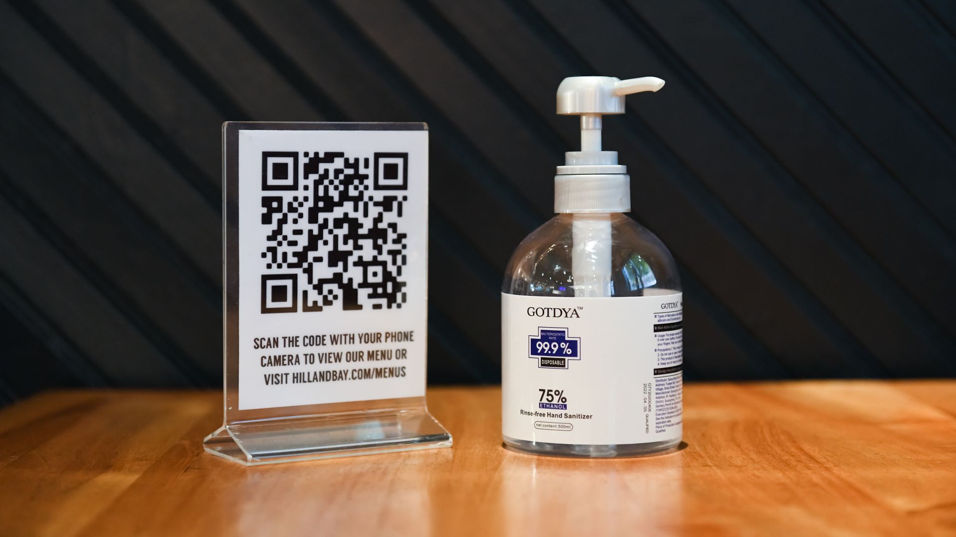 A QR code menu next to a bottle of hand sanitizer. 