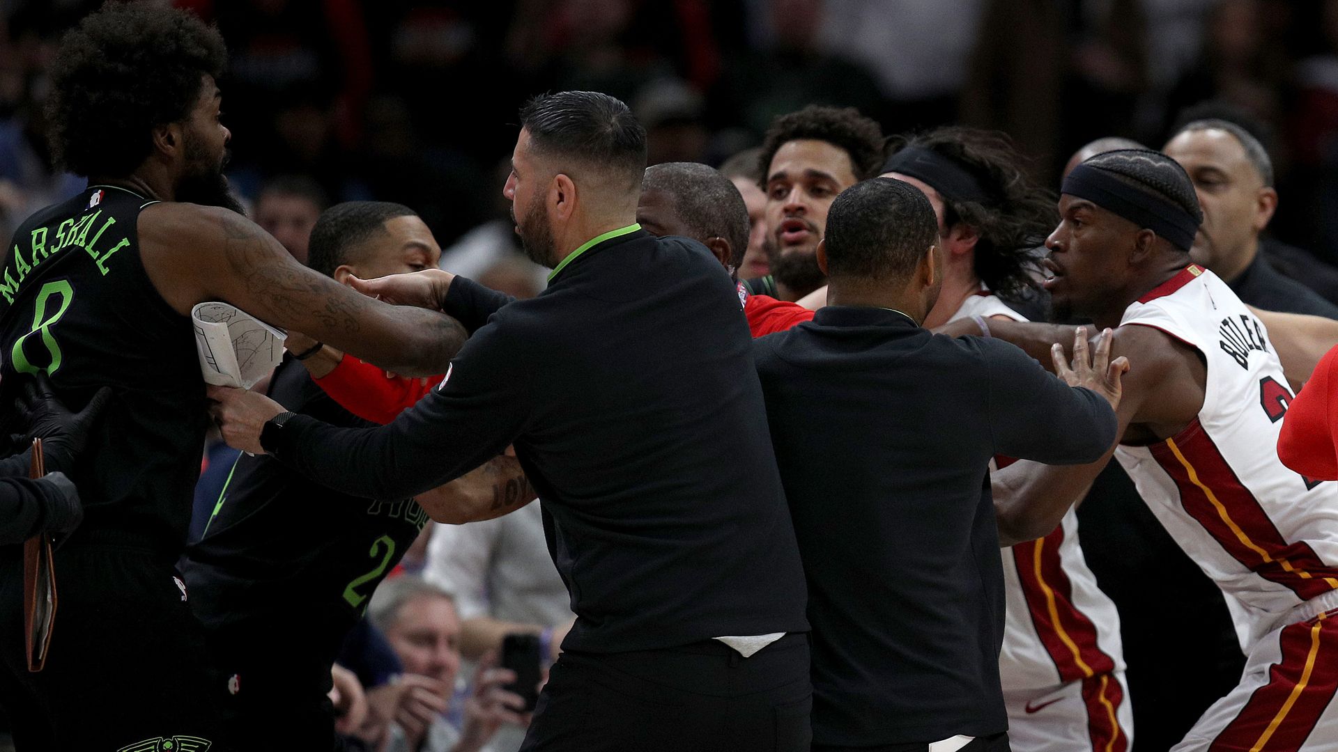 Players from the New Orleans Pelicans and the Miami Heat are restrained during an on-court fight during a game.