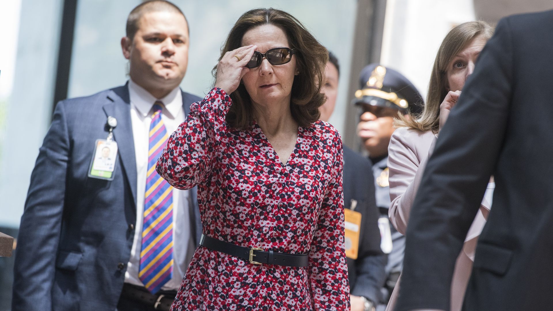 Gina Haspel holding her sunglasses, walking.