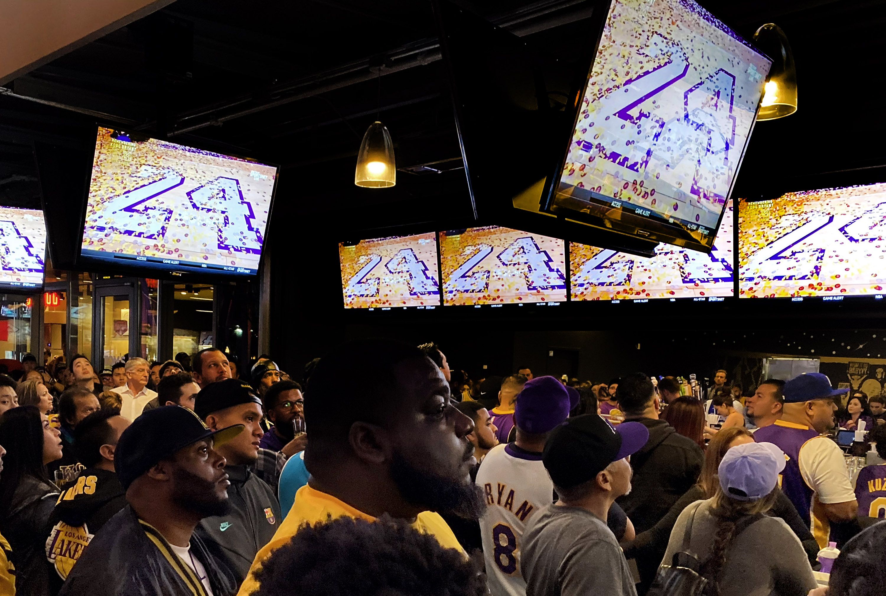 In this image, Lakers fans watch TVs with the 24 jersey number honoring Kobe