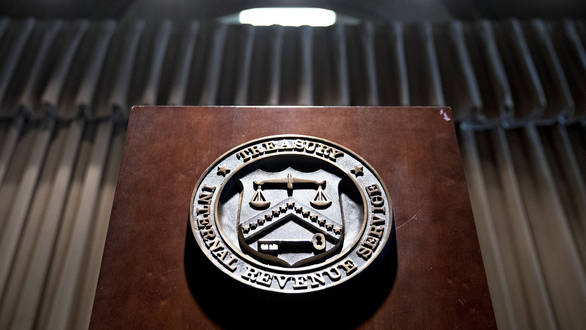 The seal of the Internal Revenue Service (IRS) hangs on a podium.