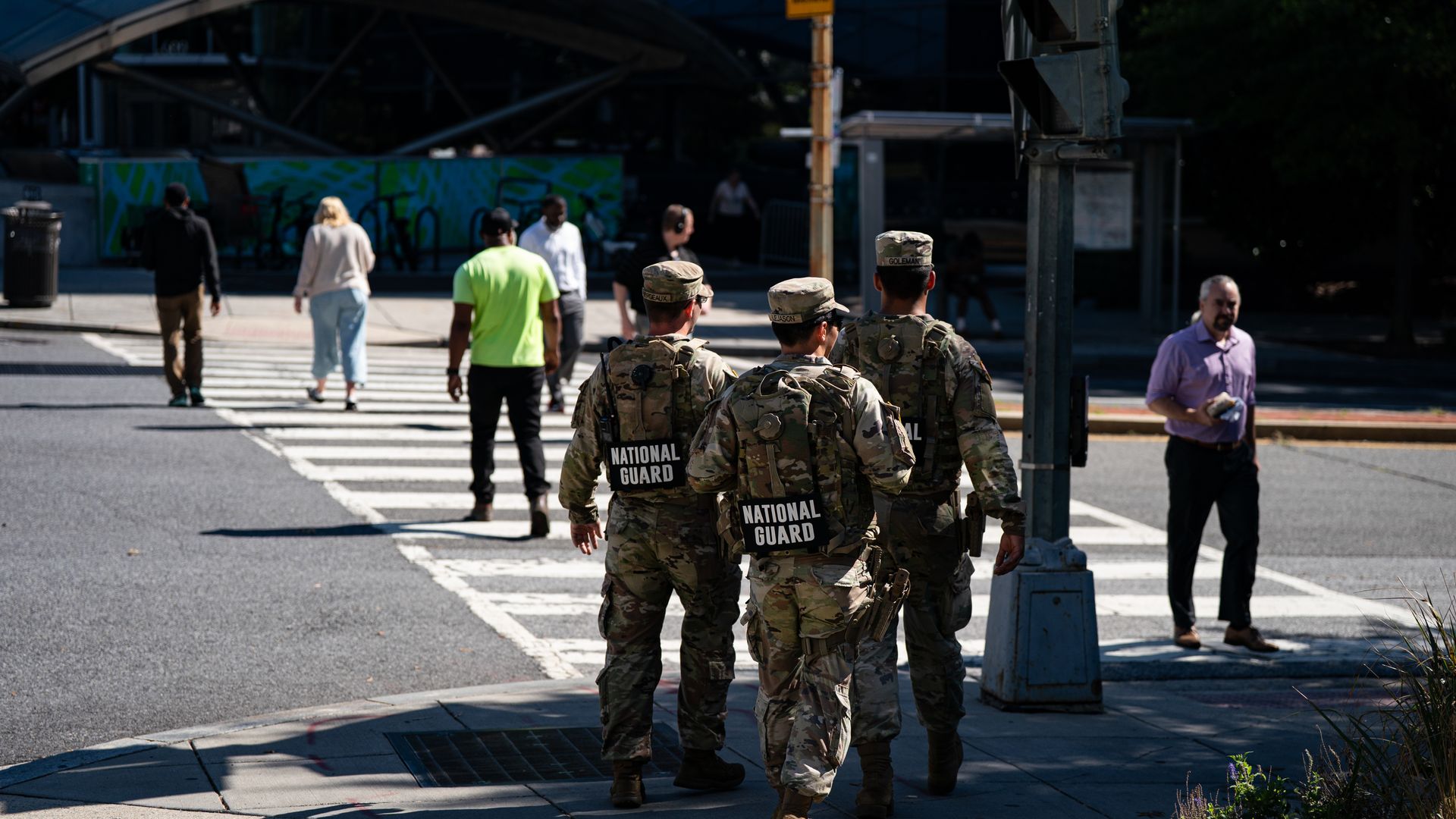 National Guard members walk on a D.C. street near a Metro station