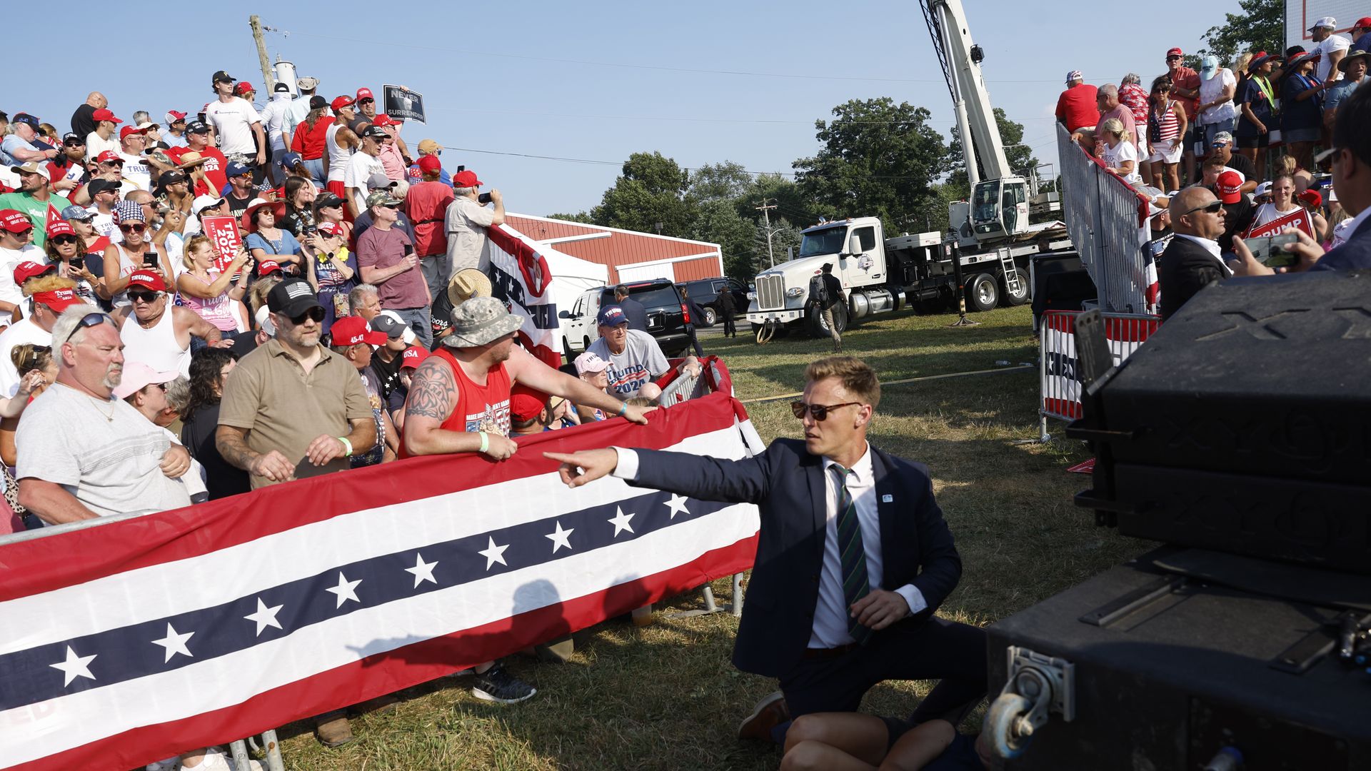 A Secret Service agent points to something in front of the crowd at Donald Trump's rally.