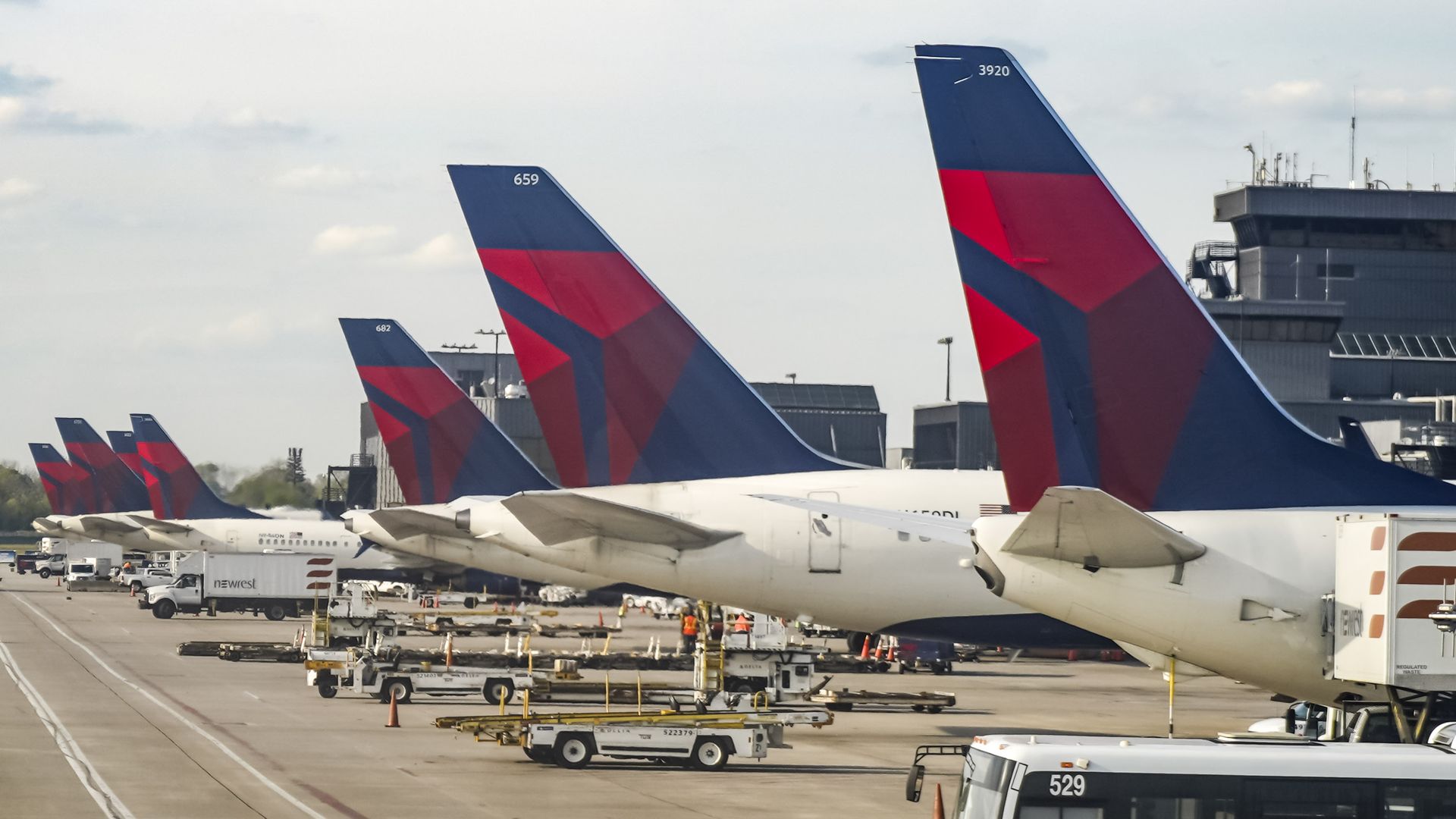 Photo of a row of Delta airplanes lined up at an airport