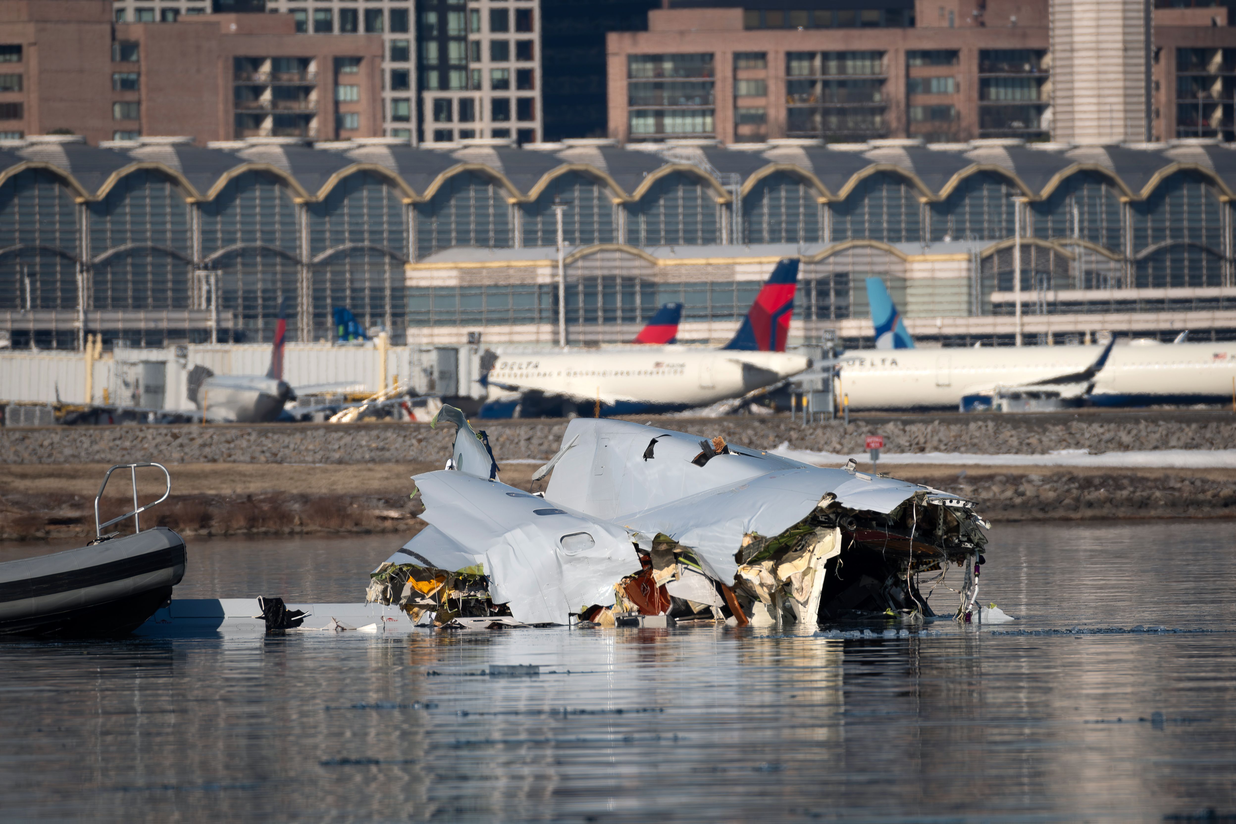 Wreckage of plane in the Potomac River, backdrop is DCA airport.