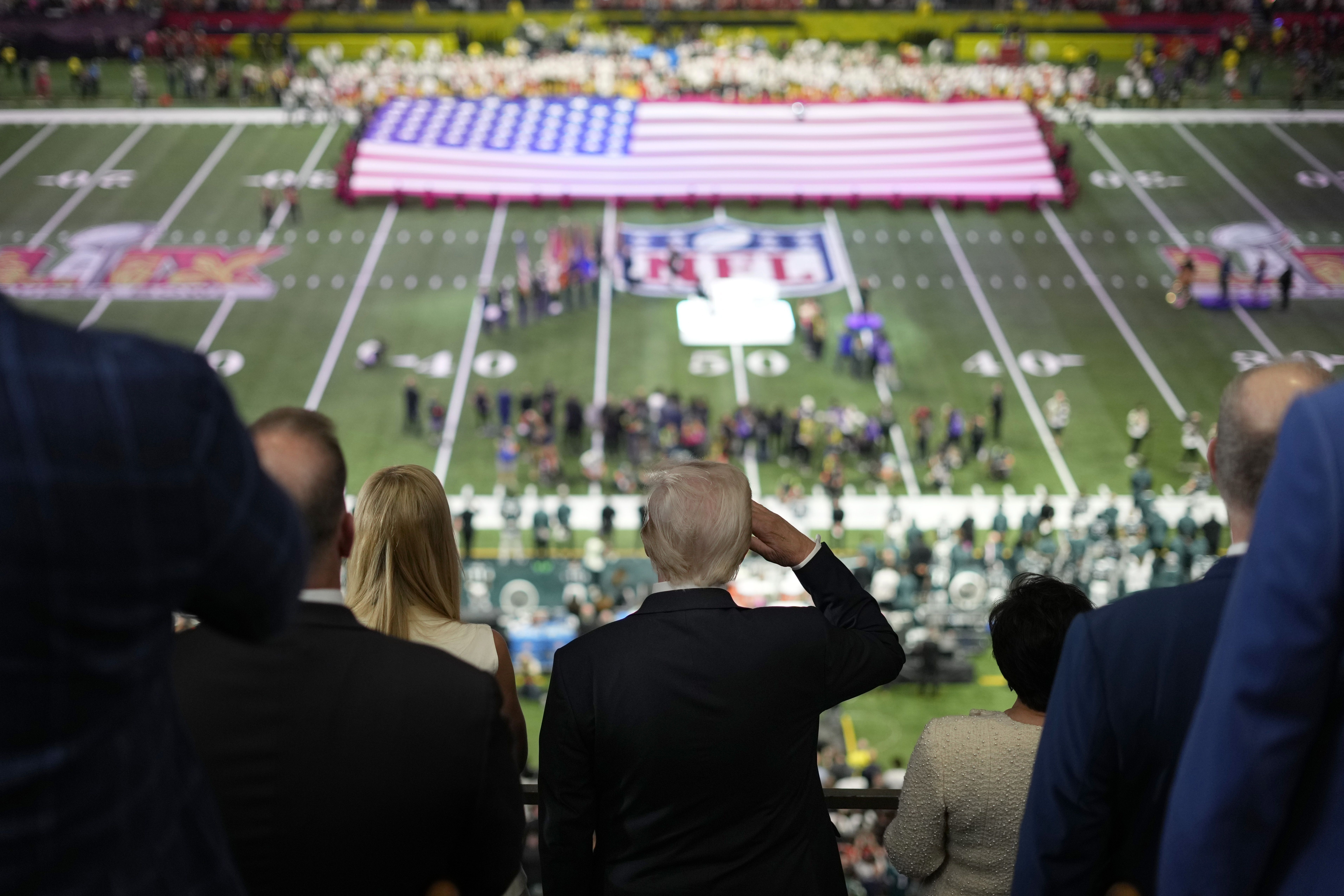 President Trump salutes as Jon Batiste performs the national anthem before Super Bowl LIX.