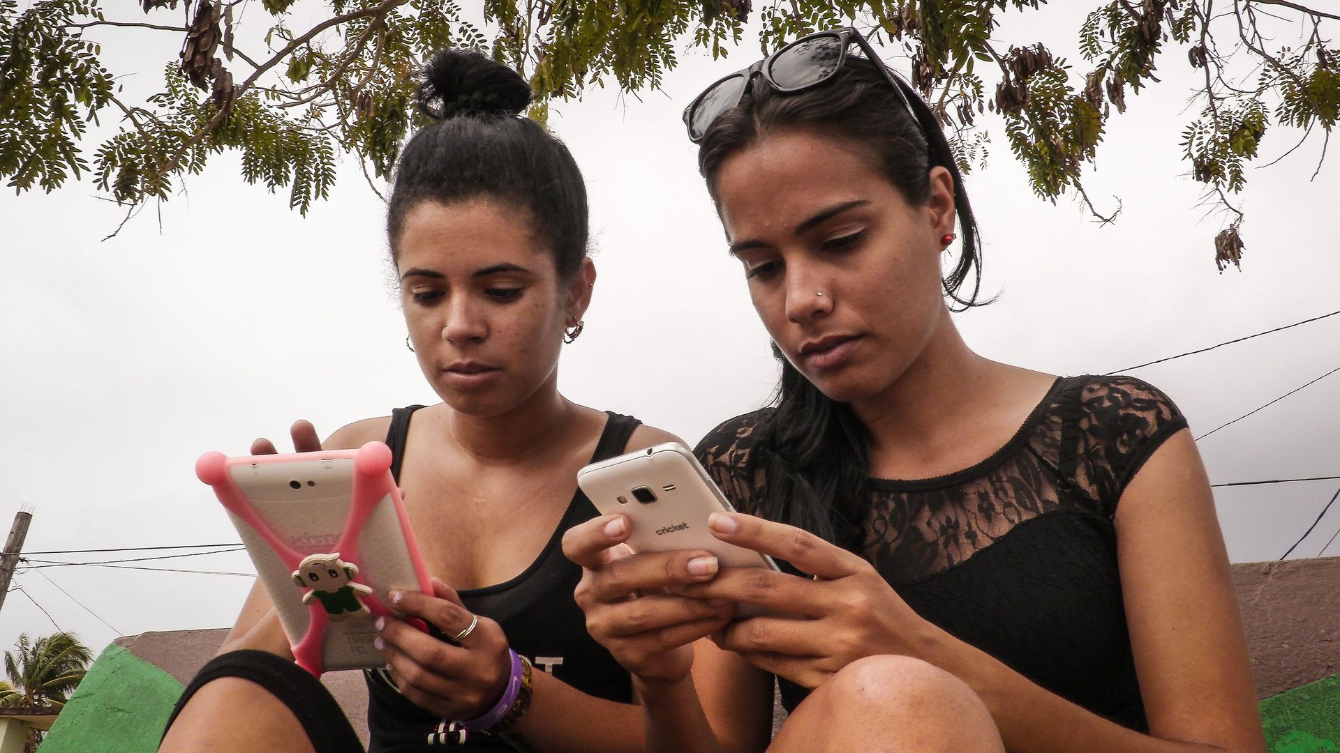 Young Cubans use WIFI on their cell phones 