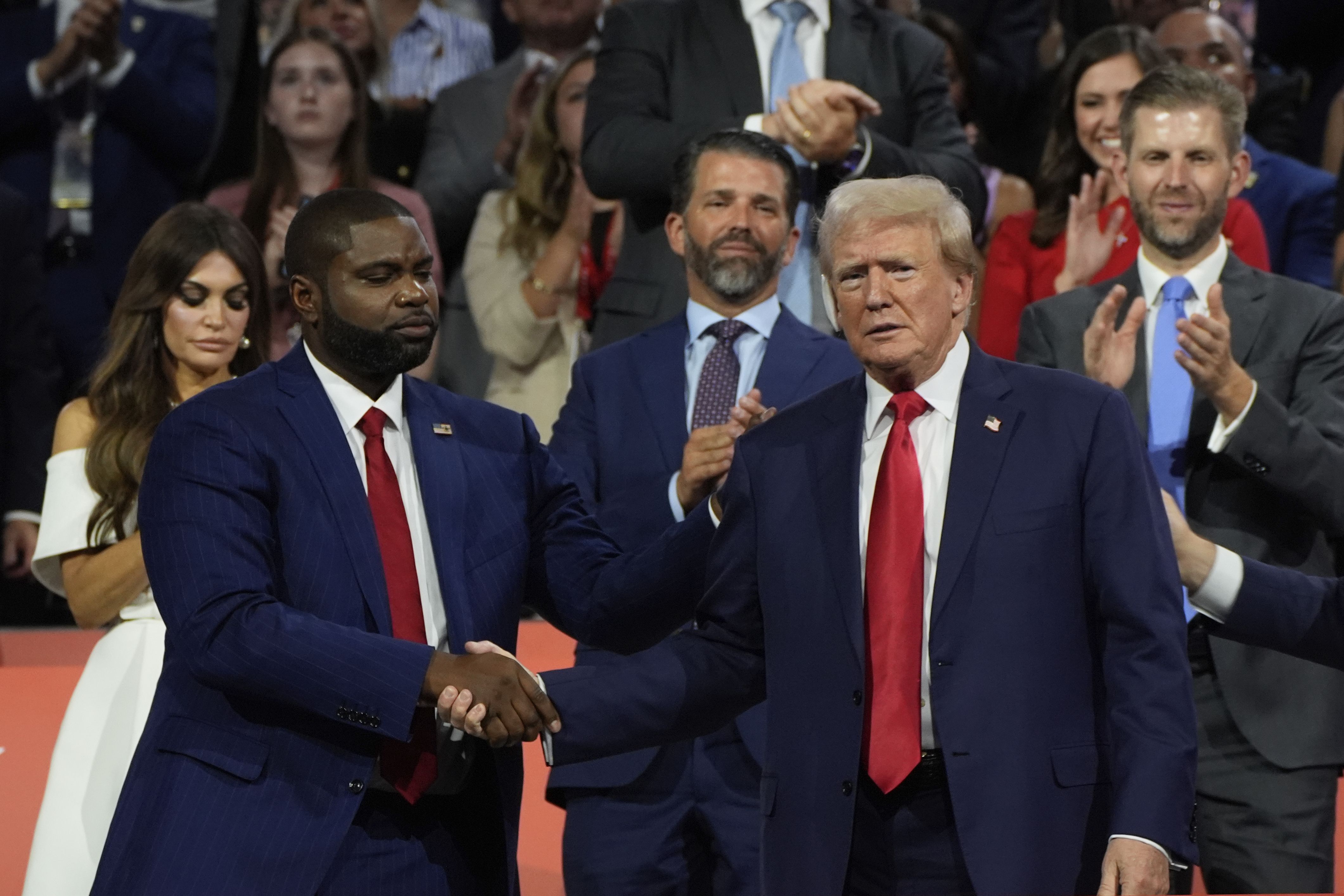 Rep. Byron Donalds (R-Fla.) and Donald Trump shake hands in front of Donald Trump Jr. at the GOP convention last year. 