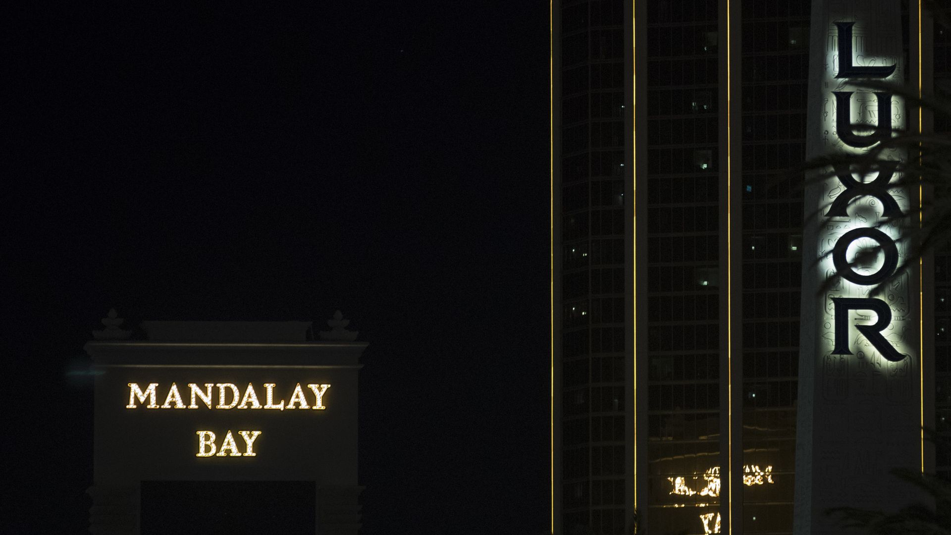 Mandalay Bay logo lit up in yellow with black background in nighttime.