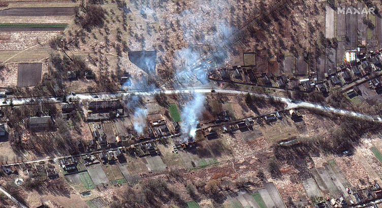 The convoy passes burning homes north of Kyiv