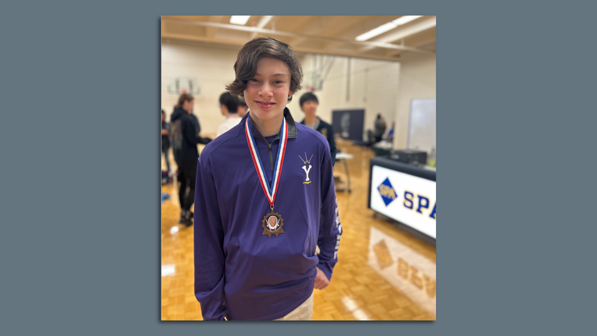 Boy with a purple shirt and a medal