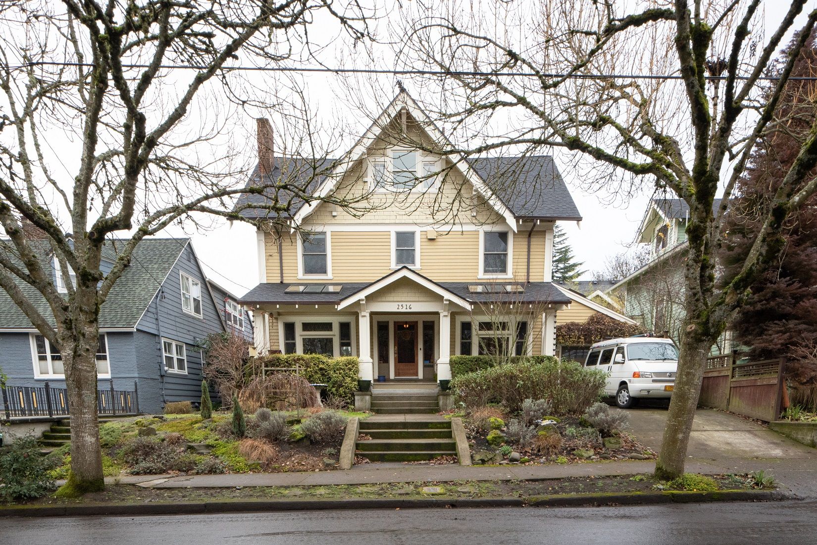 A photo of the exterior of a two-story yellow home. 